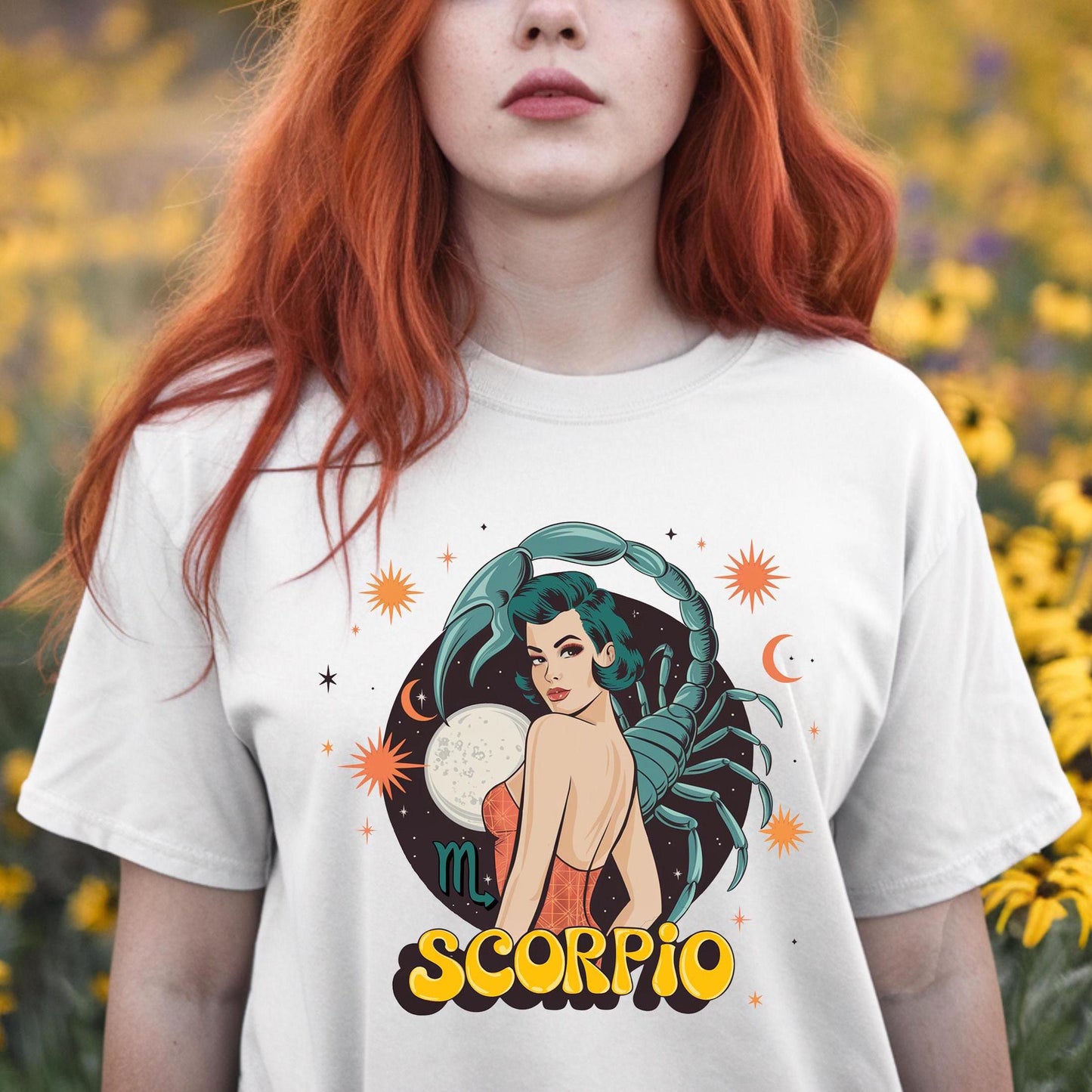 Girl in field of flowers wearing a clean white retro Scorpio tee with a minimalist vintage scorpion outline. Star sign graphic shirt for October birthdays.